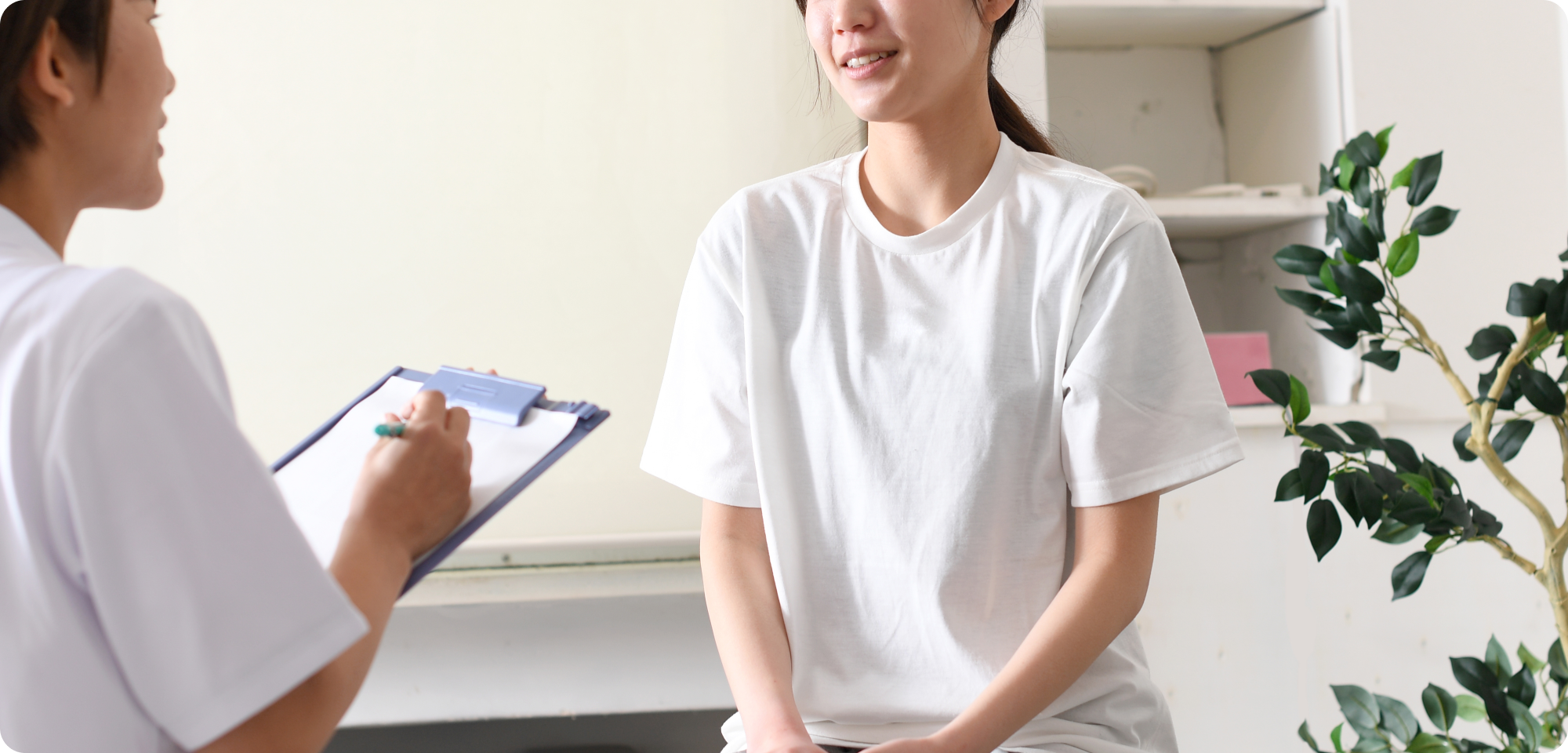 女性スタッフが患者へ問診をしている様子